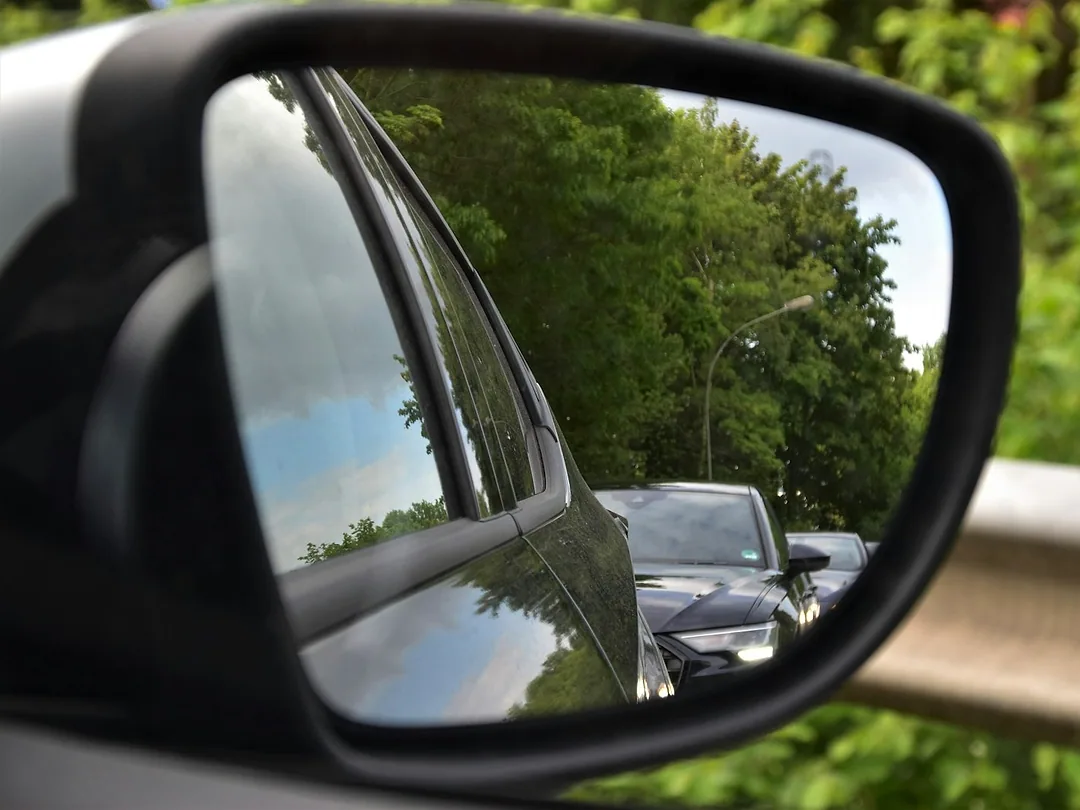 A car's side mirror showing the traffic behind